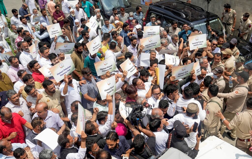 "Congress workers hold placards demanding Jammu and Kashmir statehood during foiled protest march."